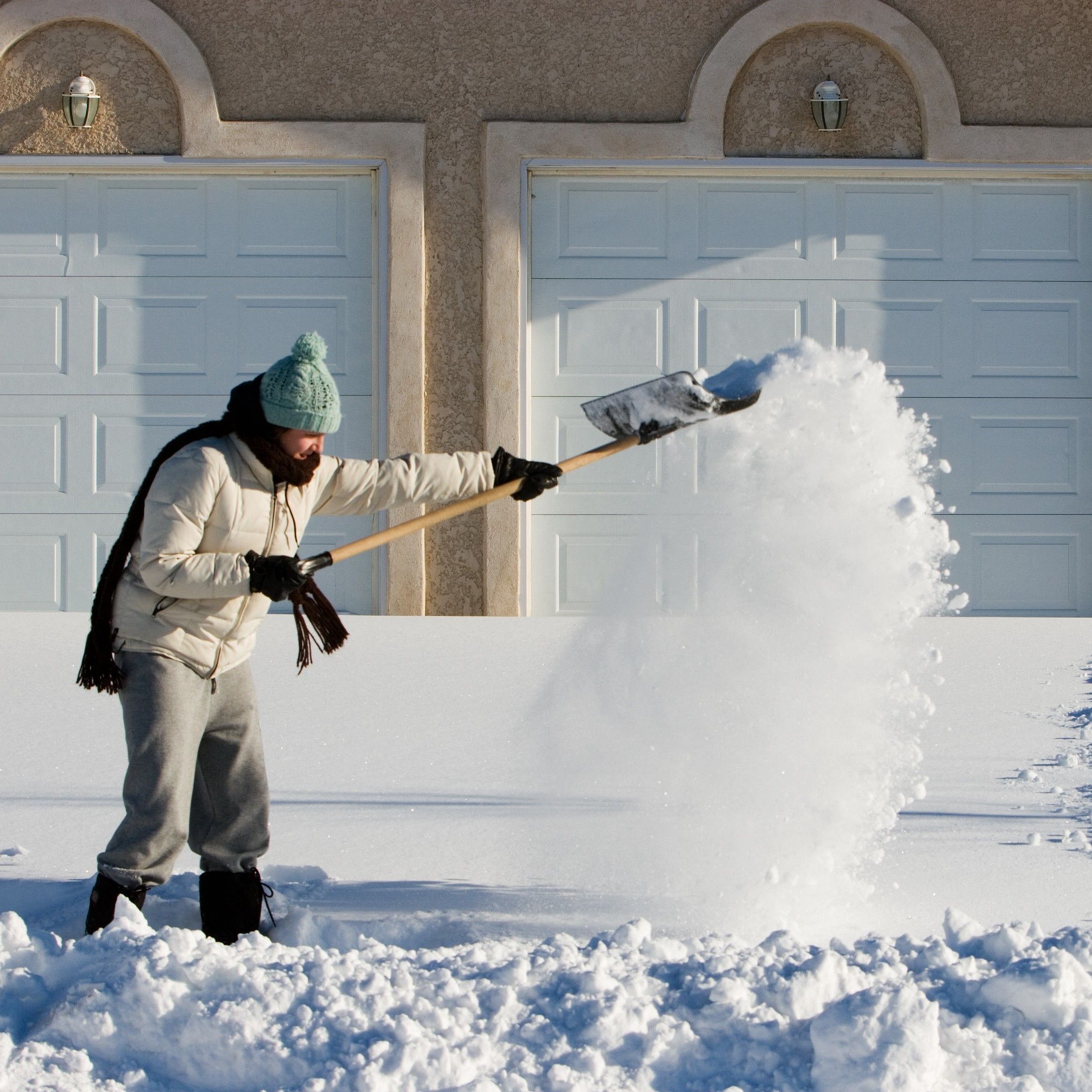 Ein Mann räumt Schnee vor seinem Haus