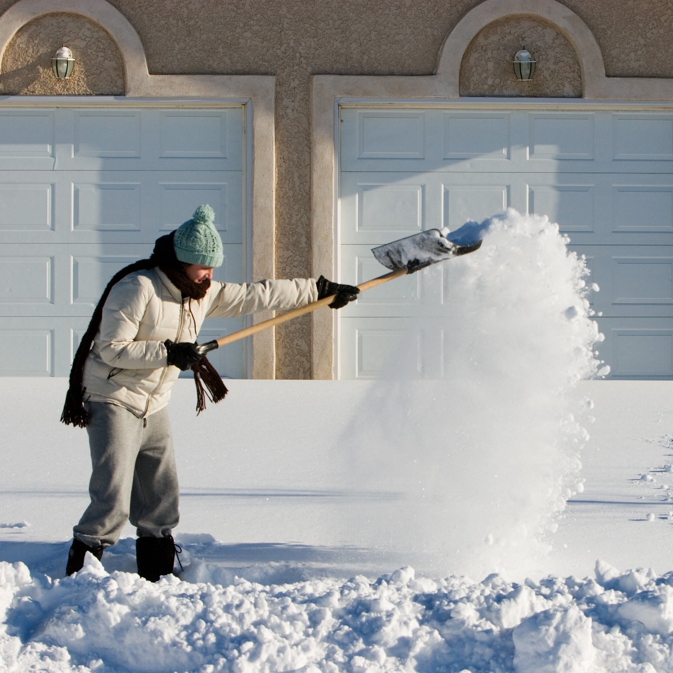 Ein Mann räumt Schnee vor seinem Haus