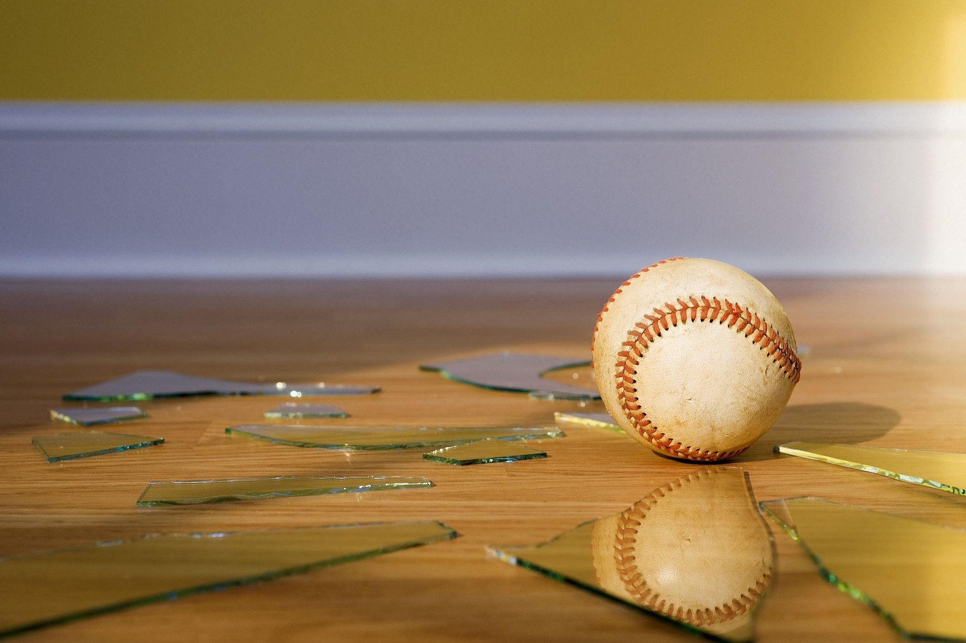 Baseball mitten in den Scherben einer Fensterscheibe