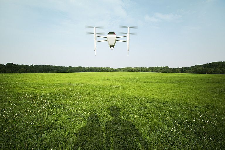Drohne fliegt über einer Wiese