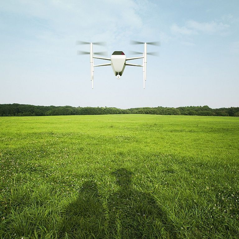Drohne fliegt über einer Wiese